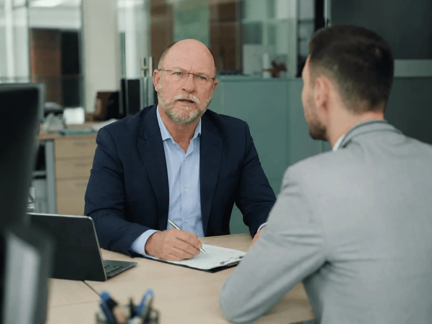 Desmond Archer advising a client across a desk