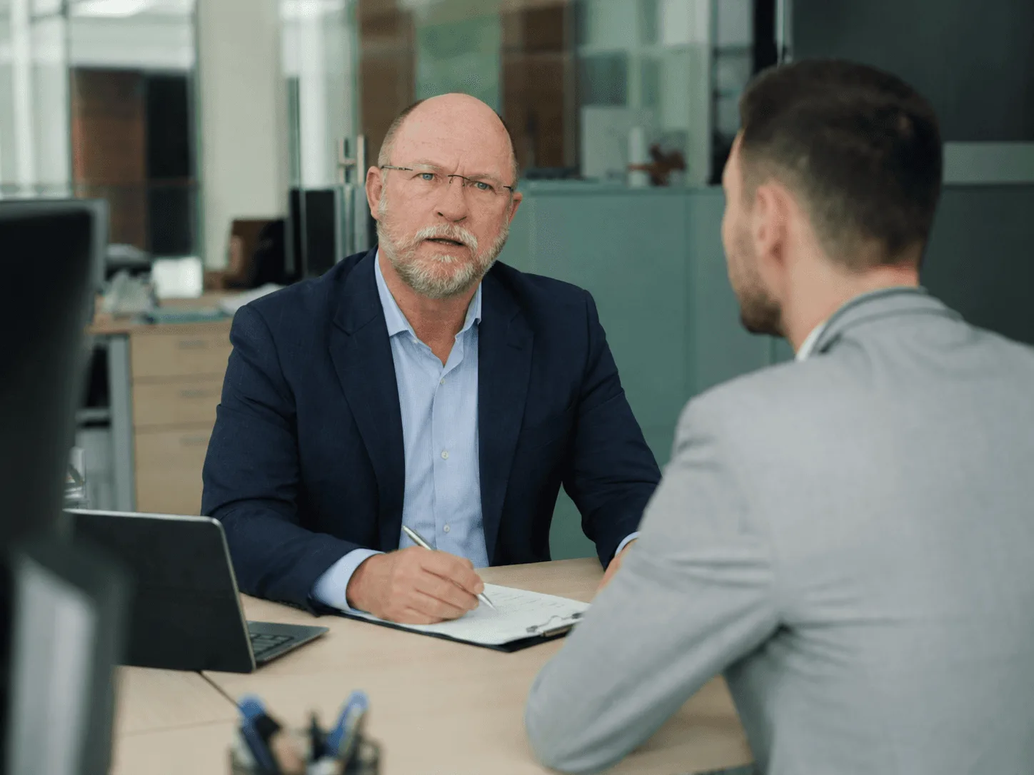 Desmond Archer advising a client across a desk